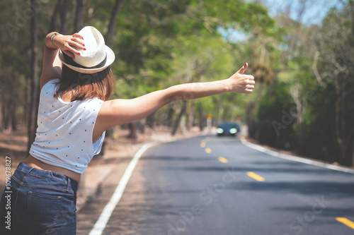 Foto Portrait of a beautiful young Asia woman hitchhiking on the road.