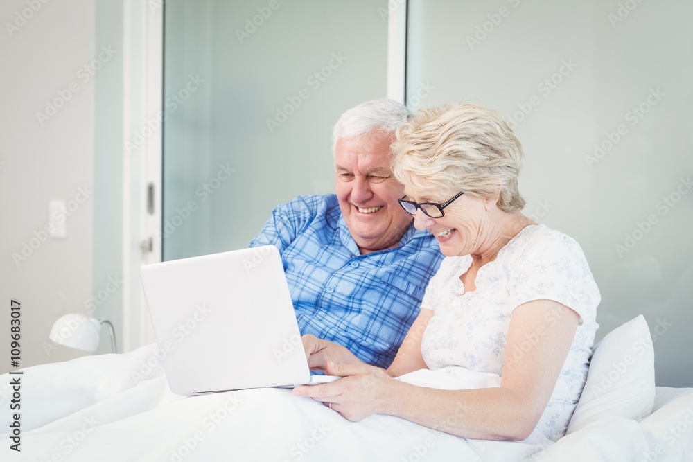 Happy couple using laptop at home Happy couple using laptop at home