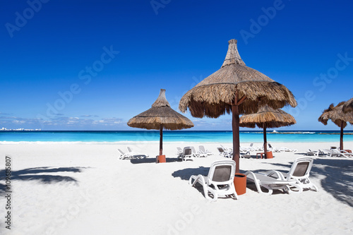 Beach chairs and sun umbrellas on a stunning tourist resort coas © photopixel