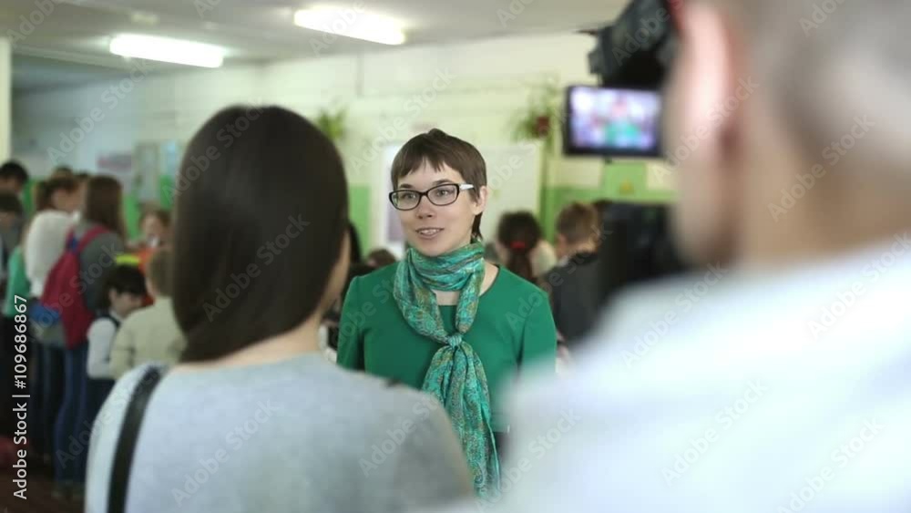 Woman with glasses gives an interview in front of camera Woman with glasses gives an interview in front of camera