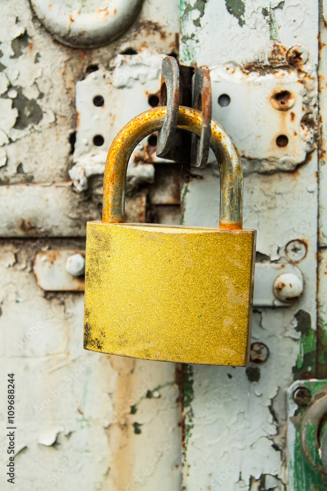close-up old rusty golden padlock on door in construction trailer close-up old rusty golden padlock on door in construction trailer