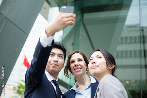 Business people taking self photo together