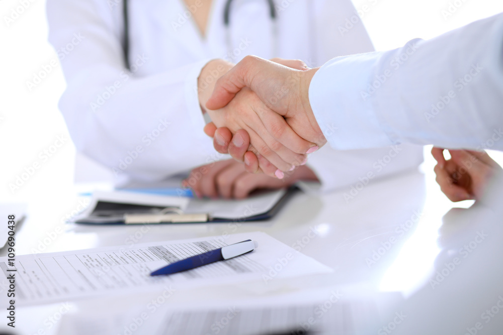 Doctor and patient handshaking. Hands close-up Doctor and patient handshaking. Hands close-up