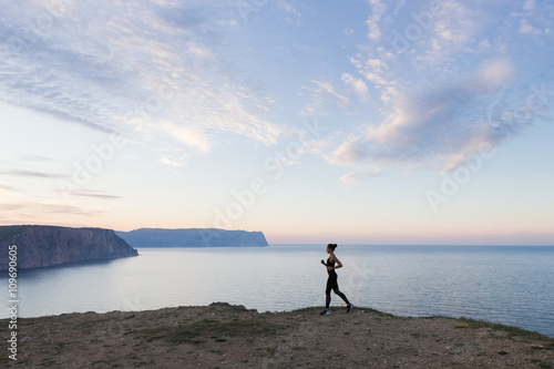Woman running in the morning along the sea coast