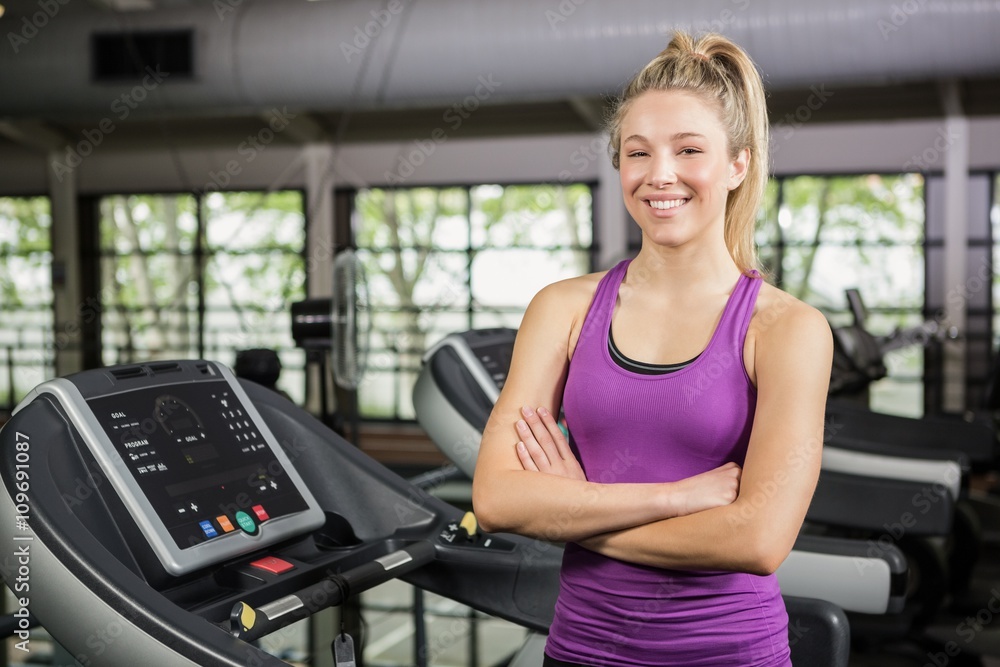 Beautiful woman standing on treadmill at gym