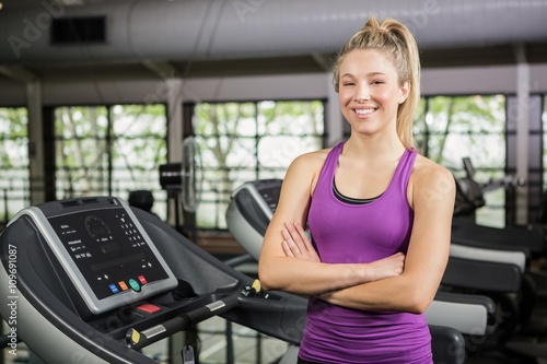 Beautiful woman standing on treadmill at gym