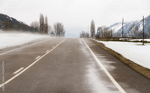 Carretera de Montaña en paisaje nevado y ventisca de nieve