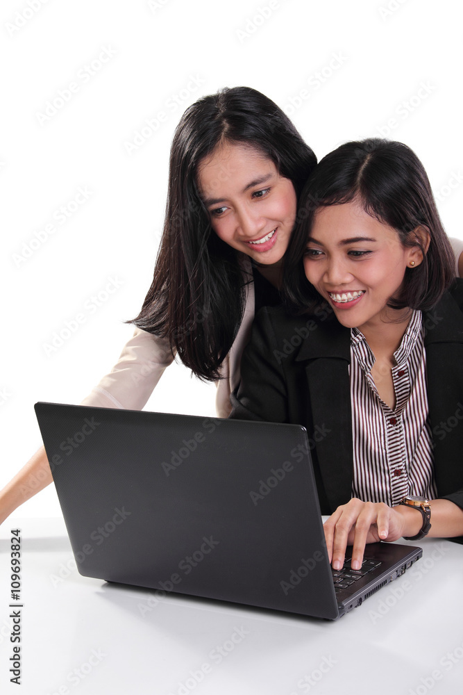 Female professionals working with laptop together Female professionals working with laptop together