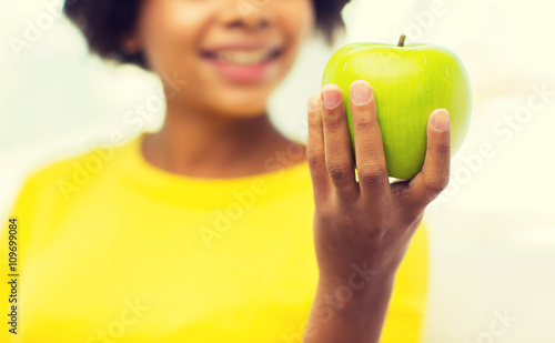 Obraz na płótnie happy african american woman with green apple