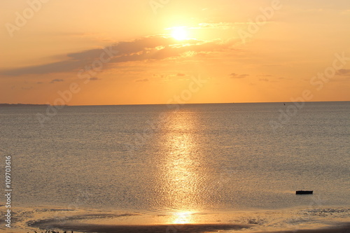 Orange golden sunrise over the Indian Ocean in Vilankulo with one fishing boat