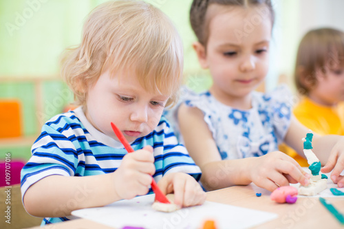 kids group learning arts and crafts in kindergarten together