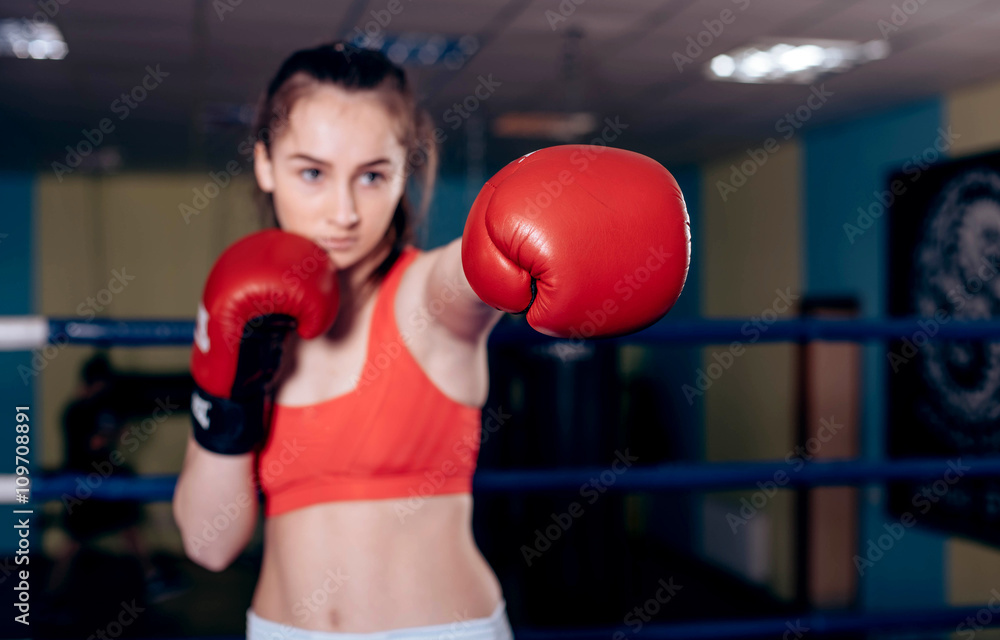 young boxing girl doing exercises on a boxing ring