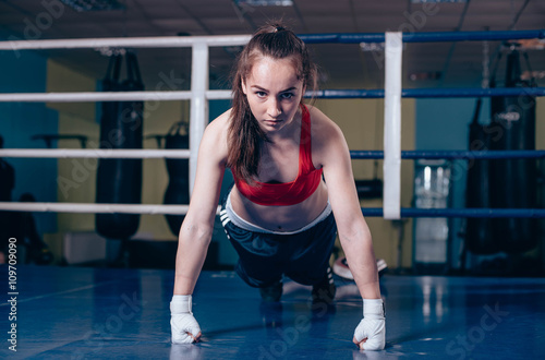 young boxing girl doing exercises on a boxing ring