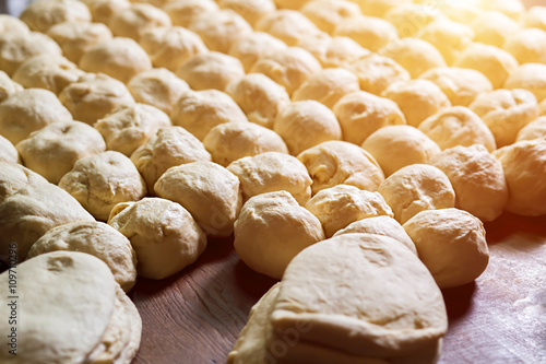 Yeast dough. Buns from dough. Dough rises on the table. Desserts making. Pies production. Baking buns. Flour products.