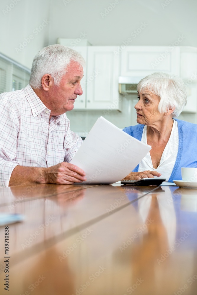 Senior couple discussing with documents Senior couple discussing with documents