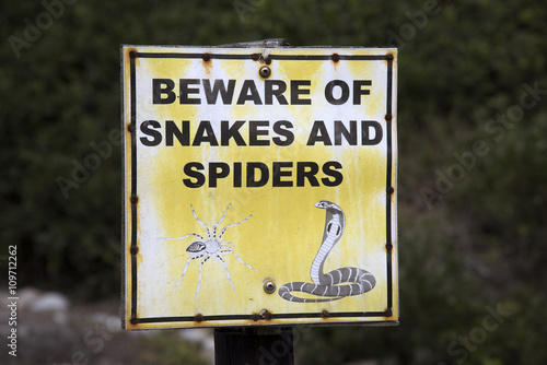 Warning sign 'Beware of Snakes and Spiders' on a roadside in Southern Africa