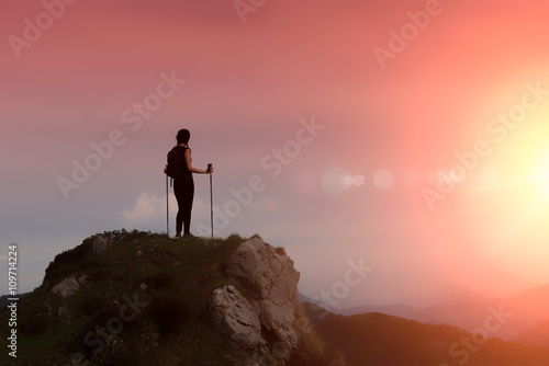 Woman in the mountains alone in a fiery sky
