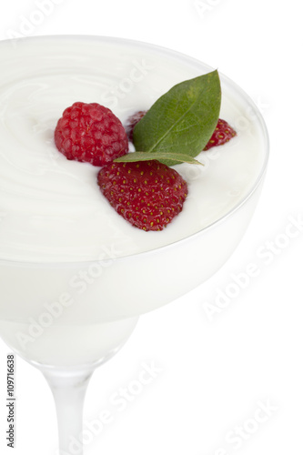 glass of white cream with raspberries