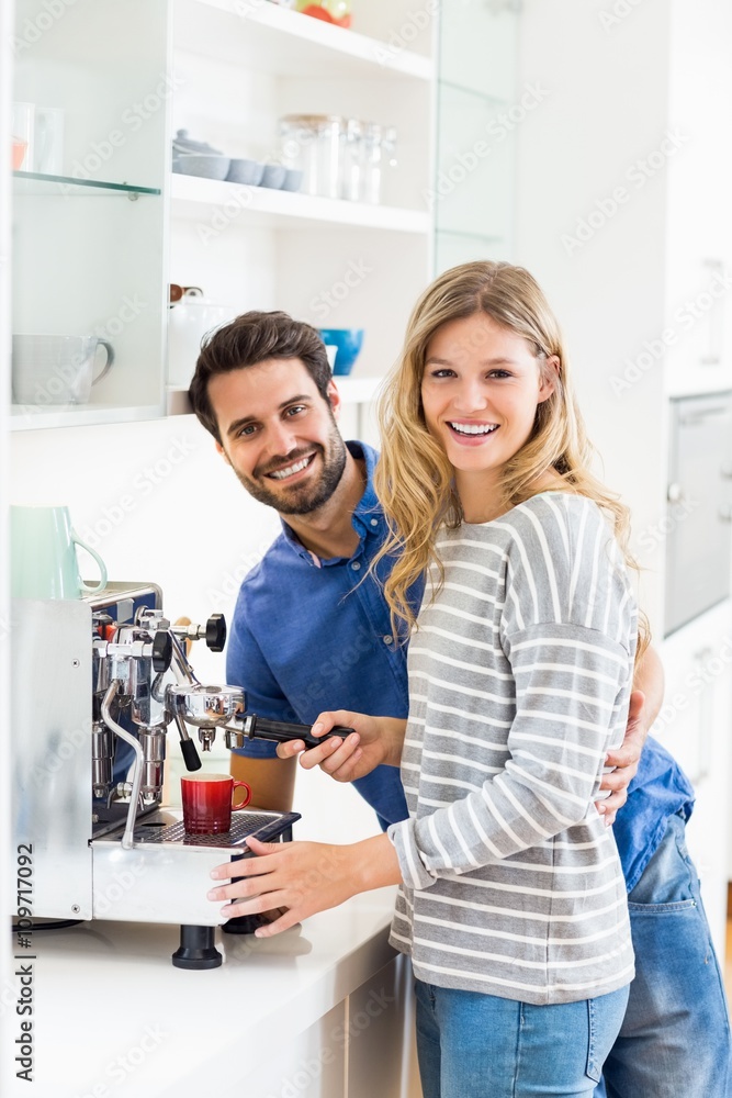 Fototapeta premium Young couple preparing coffee from coffeemaker