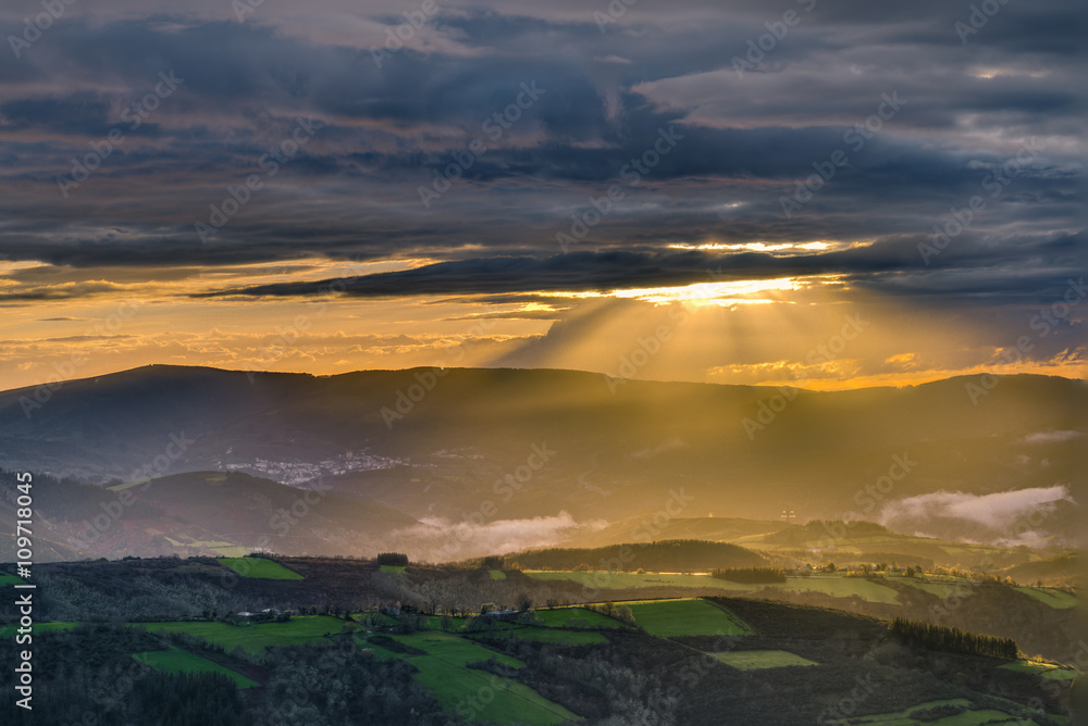 Obraz premium Sunbeams through the clouds at sunset