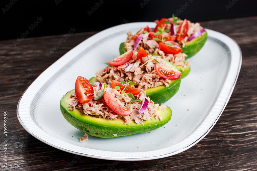 Avocado boats stuffed with tuna, red onion and cherry tomatoes. Avocado boats stuffed with tuna, red onion and cherry tomatoes.