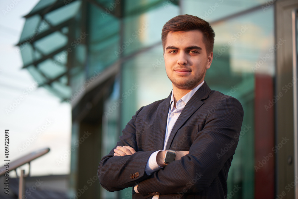 Portrait of a man in a suit against the building with a glass facade Portrait of a man in a suit against the building with a glass facade