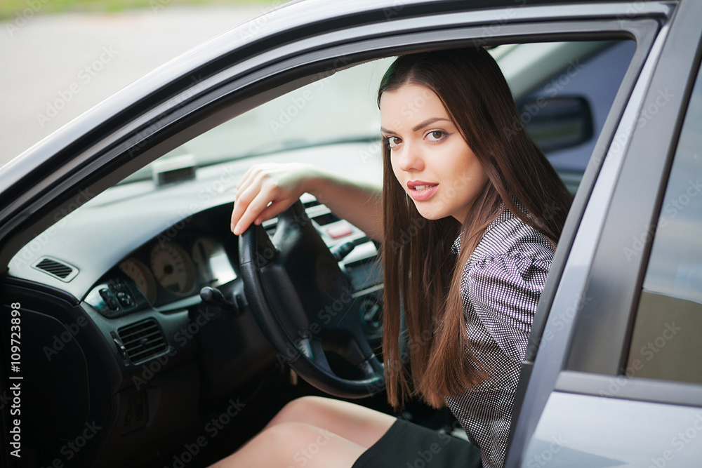 Young, attractive woman driving a car, going home from work