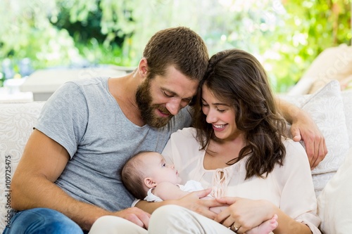 Happy parents with their baby in living room photo
