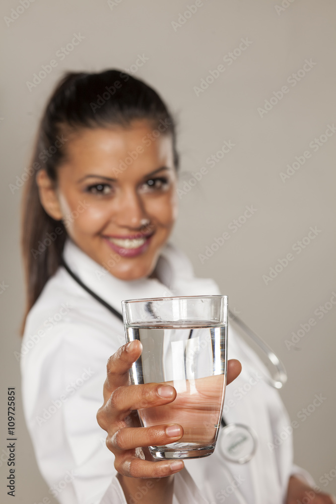 Smiling woman doctor holding a glass of water Smiling woman doctor holding a glass of water