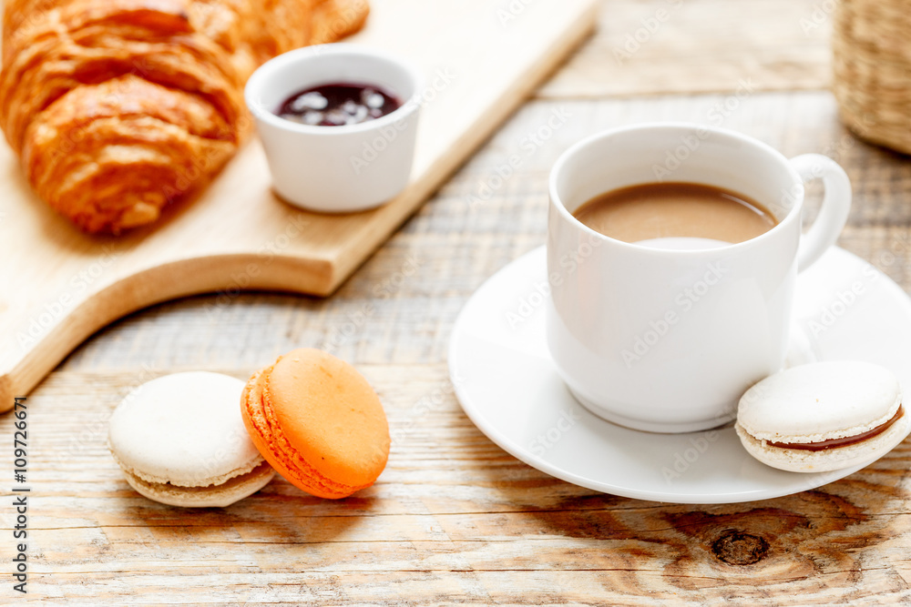 sweet breakfast with coffee, macaroons and croissants on wooden table sweet breakfast with coffee, macaroons and croissants on wooden table