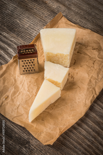 Parmesan cheese and grater on wood kitchen table