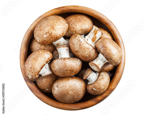 Mushrooms in wooden bowl isolated on white. Top view.