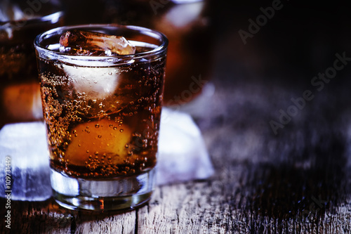 Alcoholic cocktail bourbon cola with whiskey and ice cubes, vint