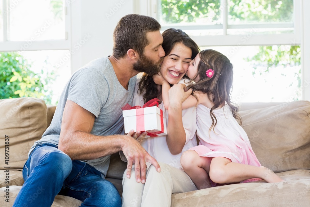 Mother receiving a gift from her husband and daughter Mother receiving a gift from her husband and daughter