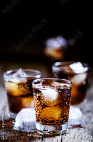 Alcoholic cocktail bourbon cola with whiskey and ice cubes, vint