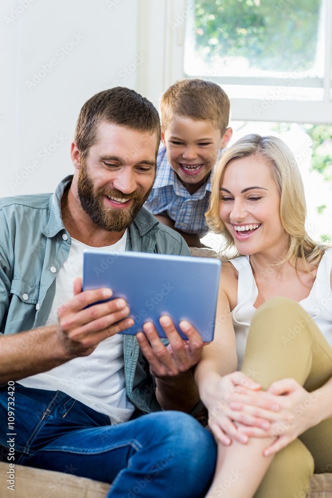 Family using digital tablet in living room Family using digital tablet in living room