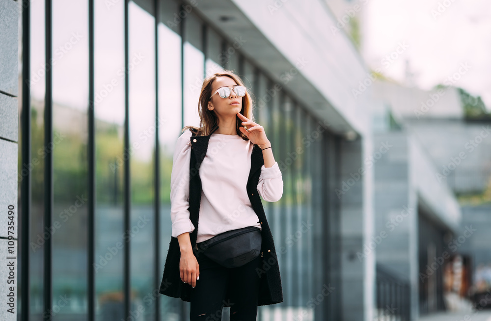 Young charming woman in fashionable sunglasses looking away