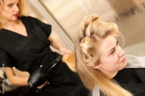 professional hair stylist at work - hairdresser doing hairstyle