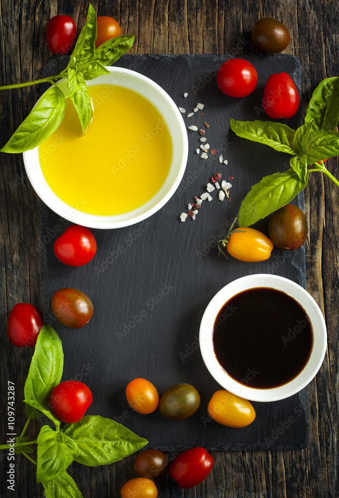 Fresh tomatoes, basil, olive oil and balsamic vinegar on wooden Fresh tomatoes, basil, olive oil and balsamic vinegar on wooden