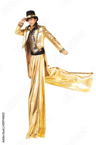 Boy in gold running on stilts