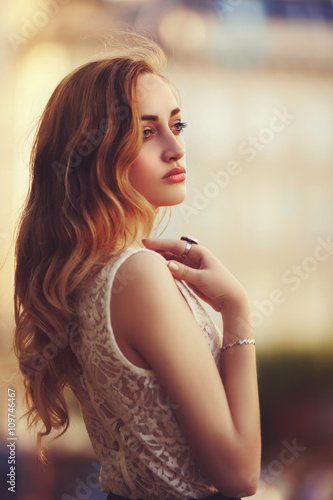 Outdoor portrait of a young beautiful fashionable lady posing on street. Model  wearing stylish clothes. Girl looking aside. Female fashion. City  lifestyle. Toned style instagram filters Stock Photo