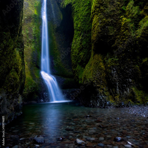 Beautiful remote waterfall in lush mossy slot canyon in Columbia River Gorge, Oregon
