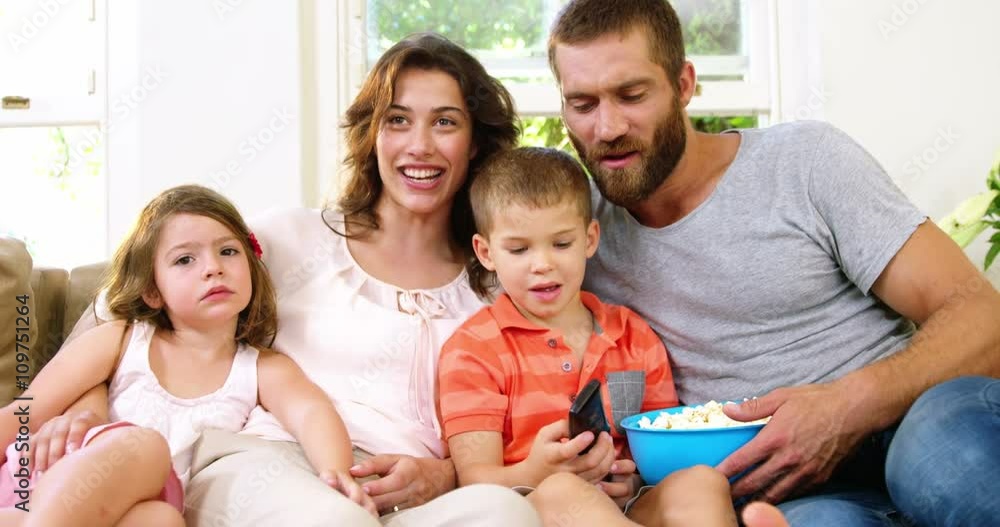 Family with pop-corn on a couch Family with pop-corn on a couch