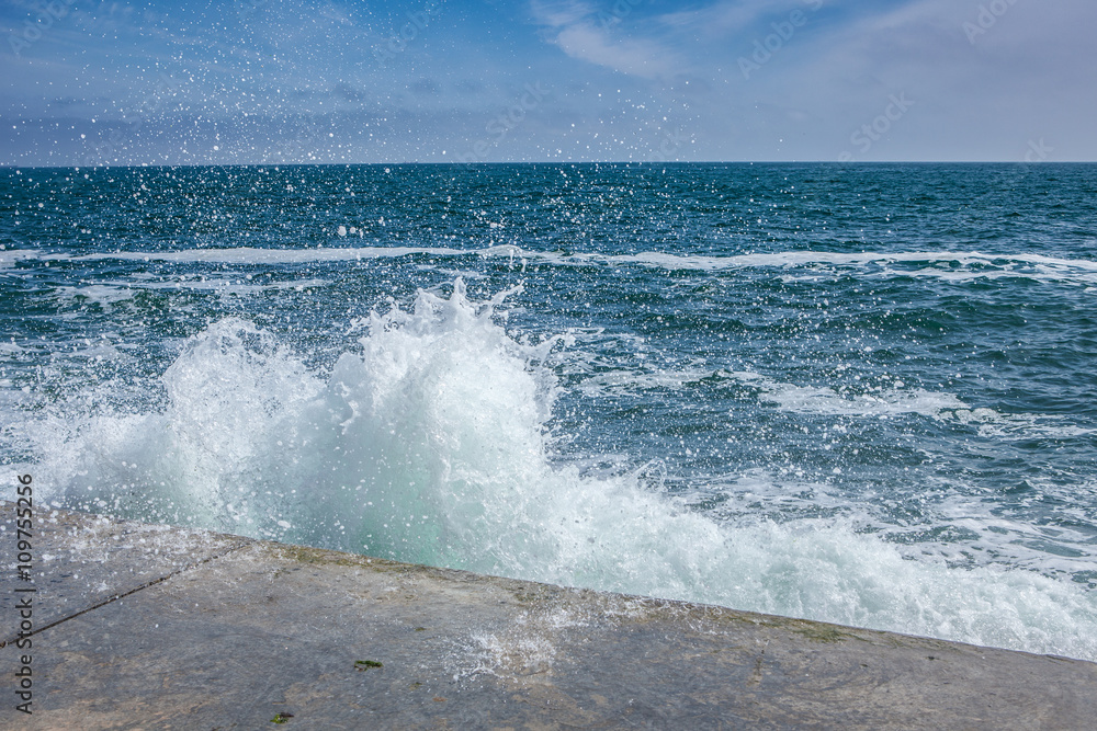 Fototapeta premium big waves on rocky coast and blue sea