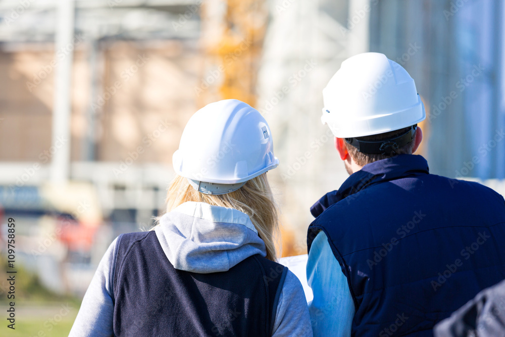 Two workers working outside on a construction site Two workers working outside on a construction site