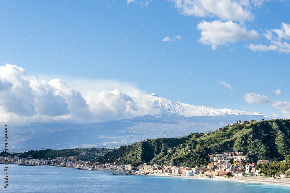 Giardini Naxos with the snowy Mount Etna in the background. Winter view from Taormina. Province of Messina. Sicily, Italy.