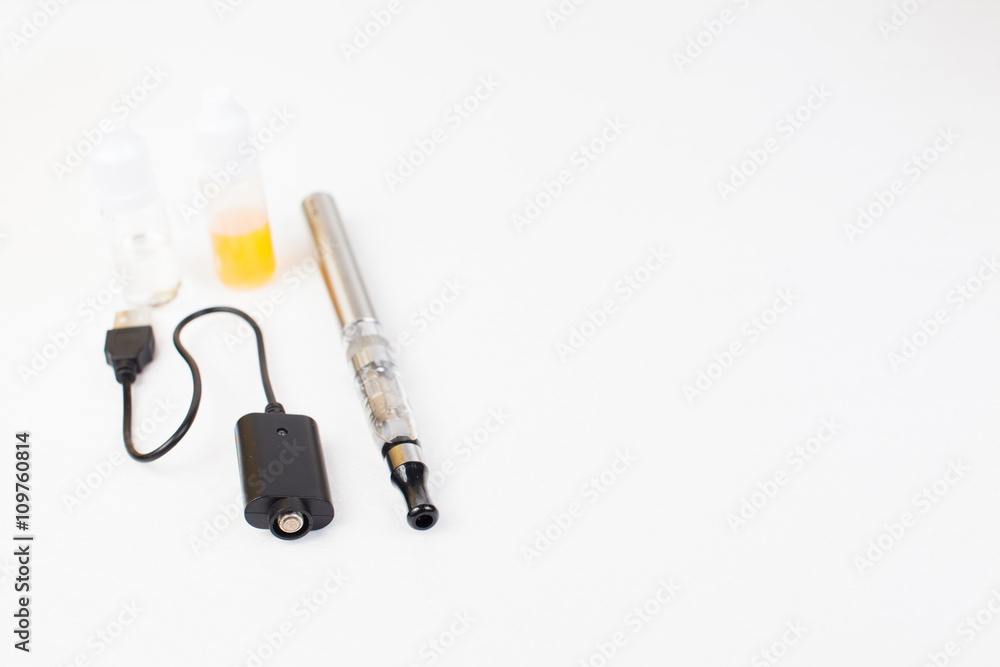 electronic nicotine inhalator on background ,bottles with liquids behind the inhalator. electronic nicotine inhalator on background ,bottles with liquids behind the inhalator.