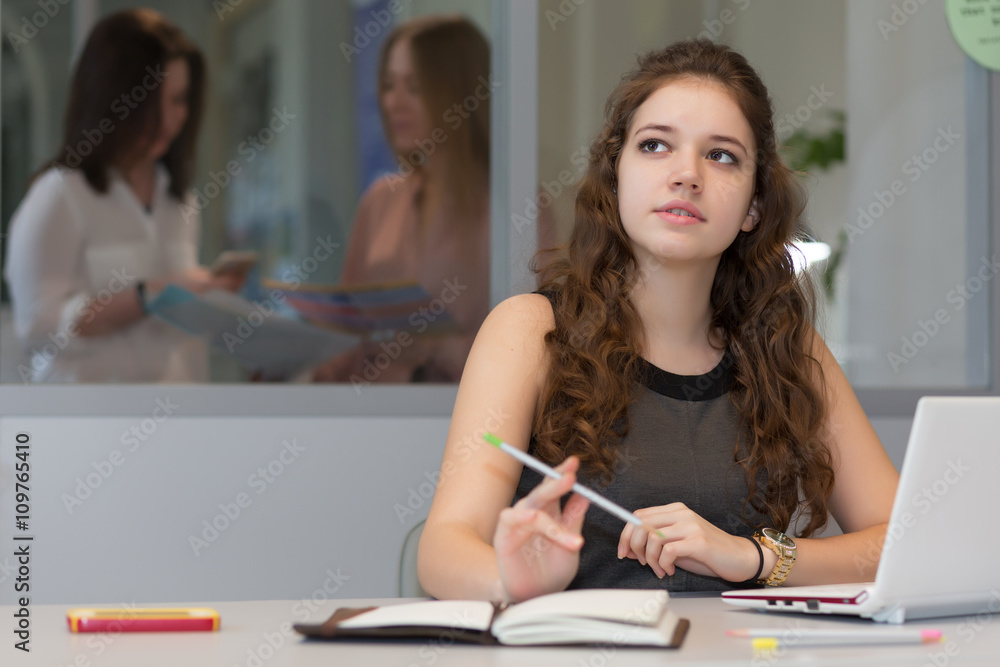 Young female Trainee working on Laptop in Office Interior Young female Trainee working on Laptop in Office Interior