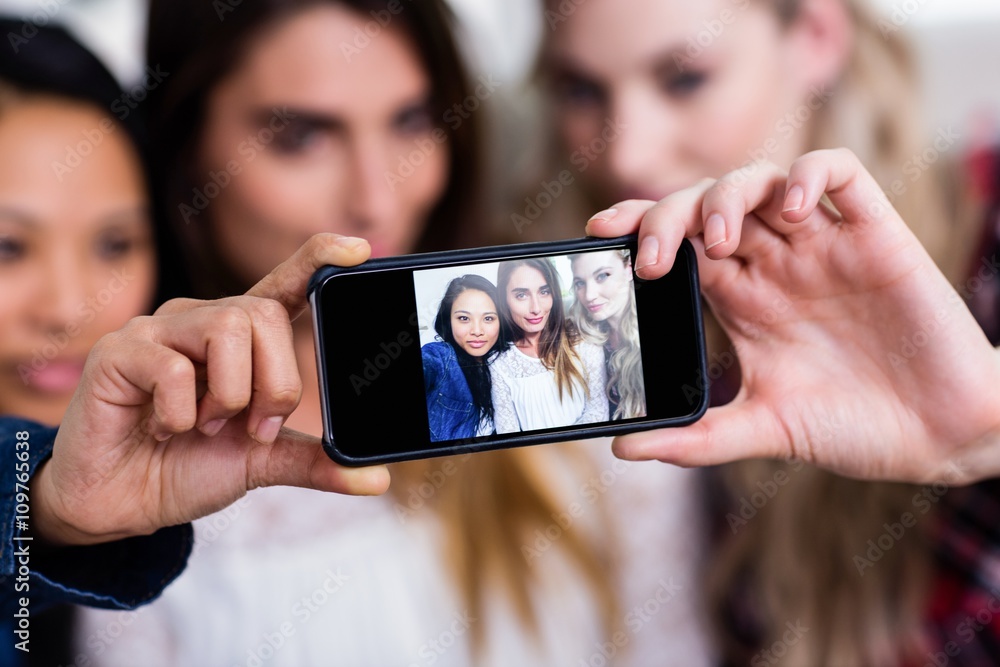 Female friends taking selfie with mobile phone at home - obrazy, fototapety, plakaty 