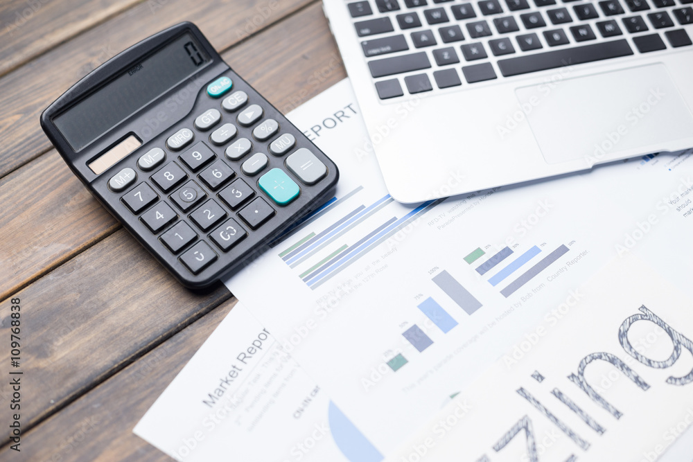 laptop and calculator on financial report laptop and calculator on financial report